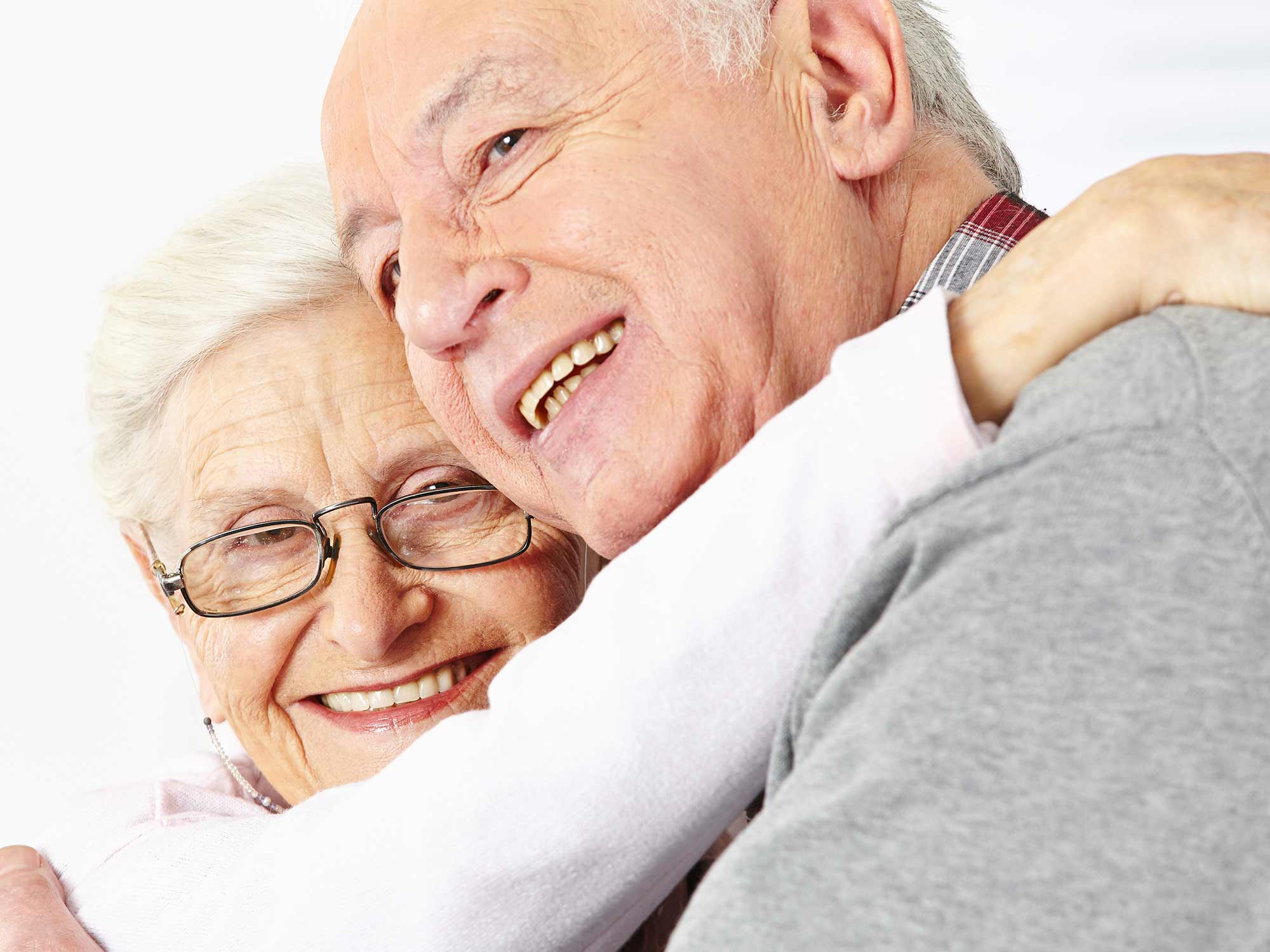 Alte Frau und alter Mann umarmen sich und freuen sich